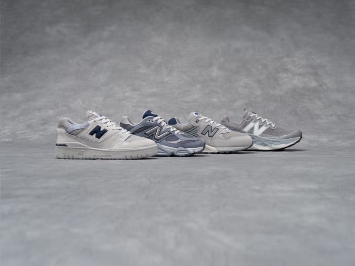 Side view of four grey New Balance sneakers.